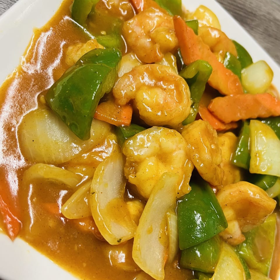 Golden Pho's shrimp stir-fry with green bell peppers, onions, and carrots in a rich sauce.